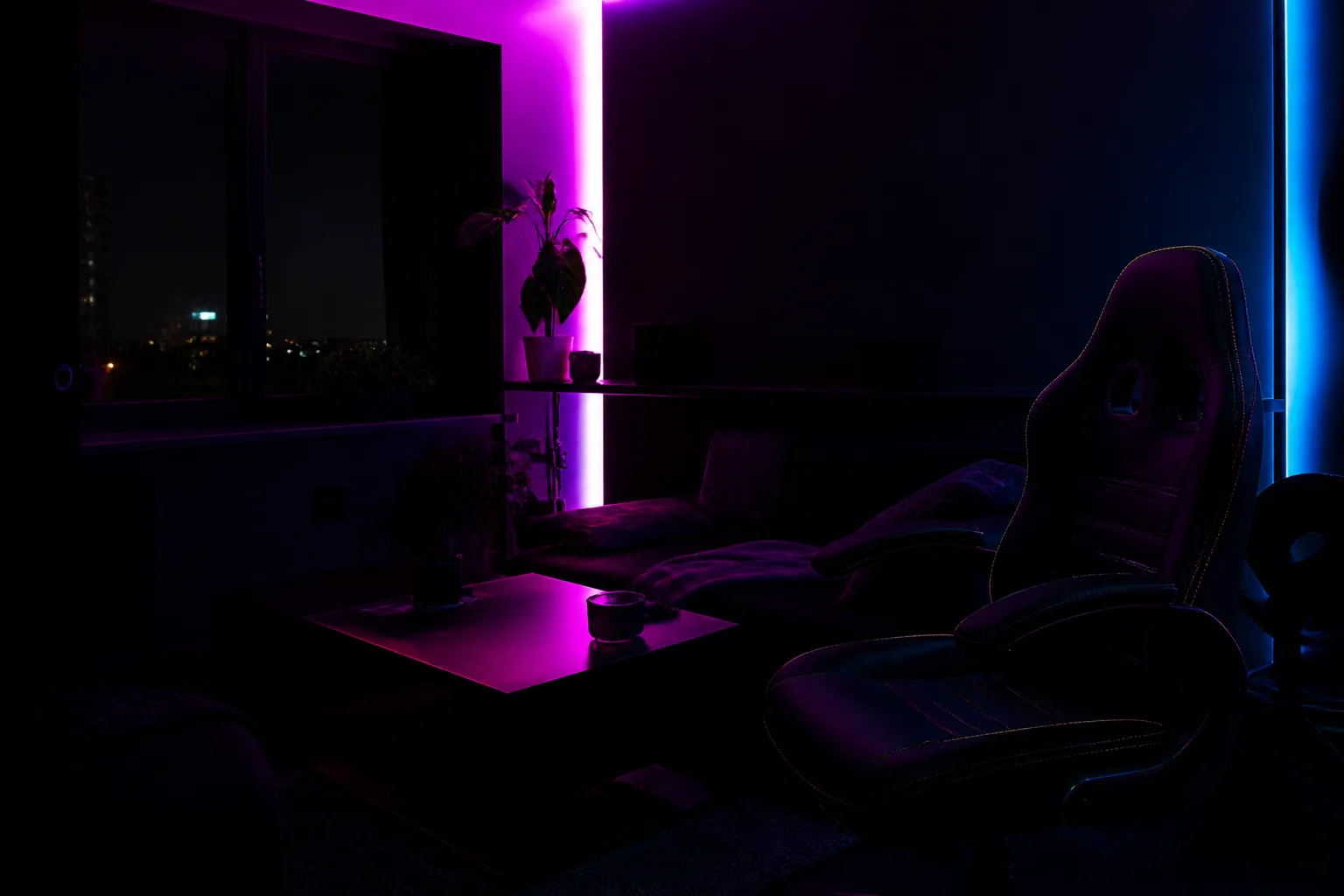 Rincón de sala gamer de noche con luz neón